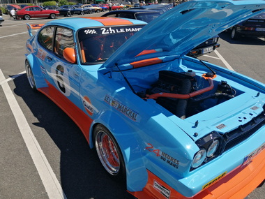 Offene Motorhauben mit gepflegtem Motorraum locken Zuschauer an
Open bonnets with well-maintained engine compartments attract spectators
Les capots ouverts avec un compartiment moteur bien entretenu attirent les spectateurs